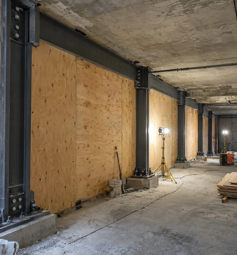 Seismic retrofit under way: steel frame and new plywood shear walls in a building basement.
