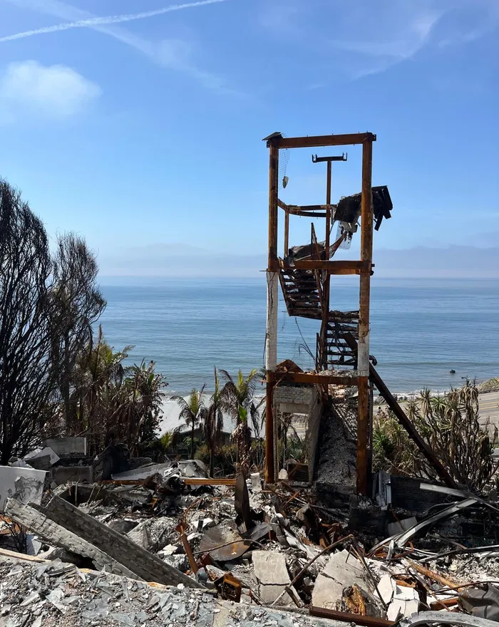 Fire-damaged coastal home reduced to its frame and rubble