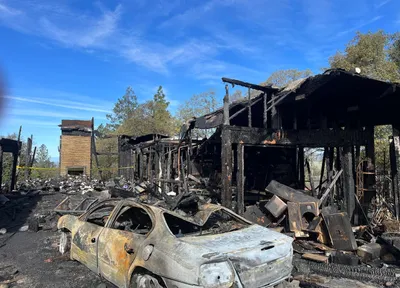 Fire-damaged wood-frame house, exterior, documented on site